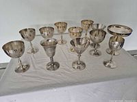 Overhead view of all twelve silver-plated goblets showing size variation