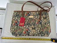 Front of Signare Golden Lily handbag with tag and measuring tape