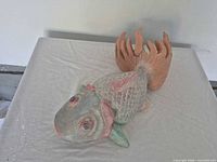 Front view of painted wooden fish sculpture showing colors and scale texture