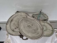 Stack of several silver plated trays showing variety