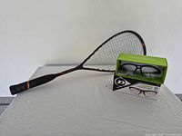 Racket and boxed eyewear on table