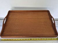 Top view of teak tray showing surface, handles, measuring tape for scale