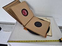 Bound album book opened showing 78 rpm discs and loose stack