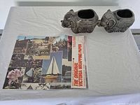 Two ceramic elephant vessels and sealed Victoria wrapping paper laid on table