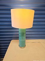 Full view of teal ceramic table lamp with shade