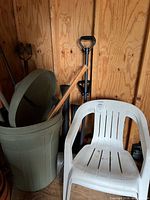Trash can, shovels and patio chair