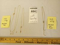Overview of both gold chains with weight notes and tag