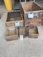 Five wooden crates and boxes grouped on concrete floor