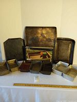 Group shot of all bakeware items: three baking sheets at back, six loaf pans front, Anchor Hocking boxed dish center