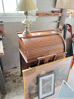 Desk with lamp on top and two framed artworks leaning in front