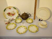 Group shot of all items: platter, teapot, mug, dessert plates, dinner plate, cup and saucer