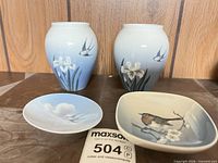 Front view of two porcelain vases, round saucer and square dish