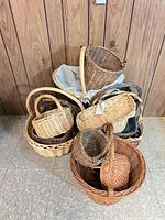Group of stacked wicker and rattan baskets against wood paneling