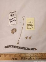 Overview of all four jewellery pieces with weight note and ruler for scale