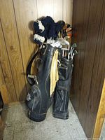 Two vintage carry bags filled with clubs and headcovers