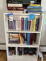 Front view of white 3-shelf bookcase filled with books
