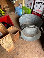 Stack of wood baskets, galvanized wash tub, mesh sifter visible