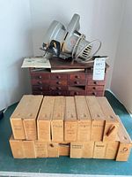 Overall lot showing saw on top of cabinet and stacked parts boxes