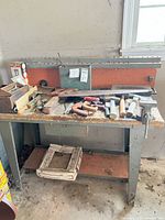 Overall view of workbench, vise, and tools on top and shelf