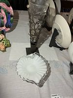 Overall view showing frosted glass vase in metal stand and white ruffled dish separated from base
