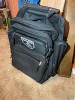Front view showing overall backpack, wheels, handle pocket, compartments