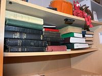 Entire first shelf showing stack of assorted Bibles and religious books