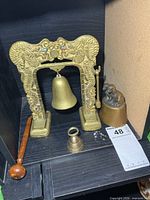 Front view showing all three brass bells, dragon stand and wooden striker