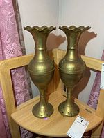 Front view of the two brass vases showing full shape and patina