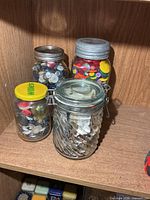 All four jars of buttons on shelf