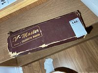 Closed burgundy V-Master cardboard box showing branding
