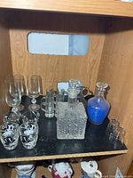 Shelf view showing both decanters and assortment of glasses