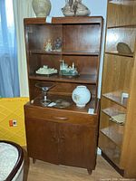 Full front view of wooden display cabinet with glass upper section and lower storage
