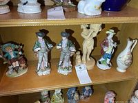 Shelf showing five figurines and bud vase