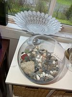 Pedestal dish at back, fish bowl with stones in foreground