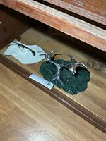 Two Hoselton aluminum bird sculptures on stone bases lying on shelf