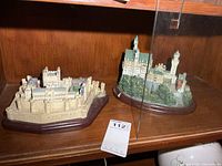 Both Lenox castle figurines on shelf with lot tag