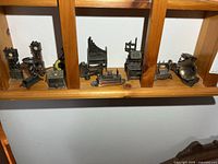 Shelf view showing multiple bronze-tone miniature sharpeners