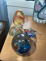 All four glass paperweights on tabletop