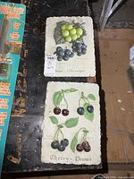 Both resin fruit plaques side by side on table