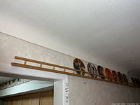 Long oak plate rack mounted above doorway displaying plates