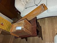 Shoeshine box open on side table, wall shelf visible