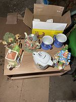 All five teapots and two mugs on small table
