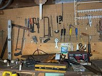 Overall view of pegboard wall and benchtop with assorted hand tools and charger