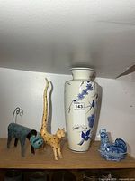 Group shot showing vase, metal cat, wooden cat, porcelain chicken
