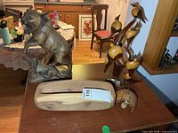 Overview showing carved cat figurine, bird tree sculpture, wood trough bowl and turtle