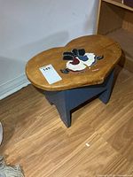 Stool front view showing blue painted base and decorative top
