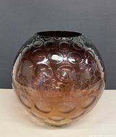 Full front view of round amber bubble-pattern crystal vase with foil label
