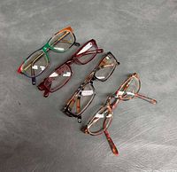 Four eyeglass frames arranged on surface