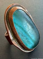 Front view showing blue glass cabochon in copper bezel