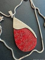 Full view of necklace laid flat showing chain style, pendant shape and color